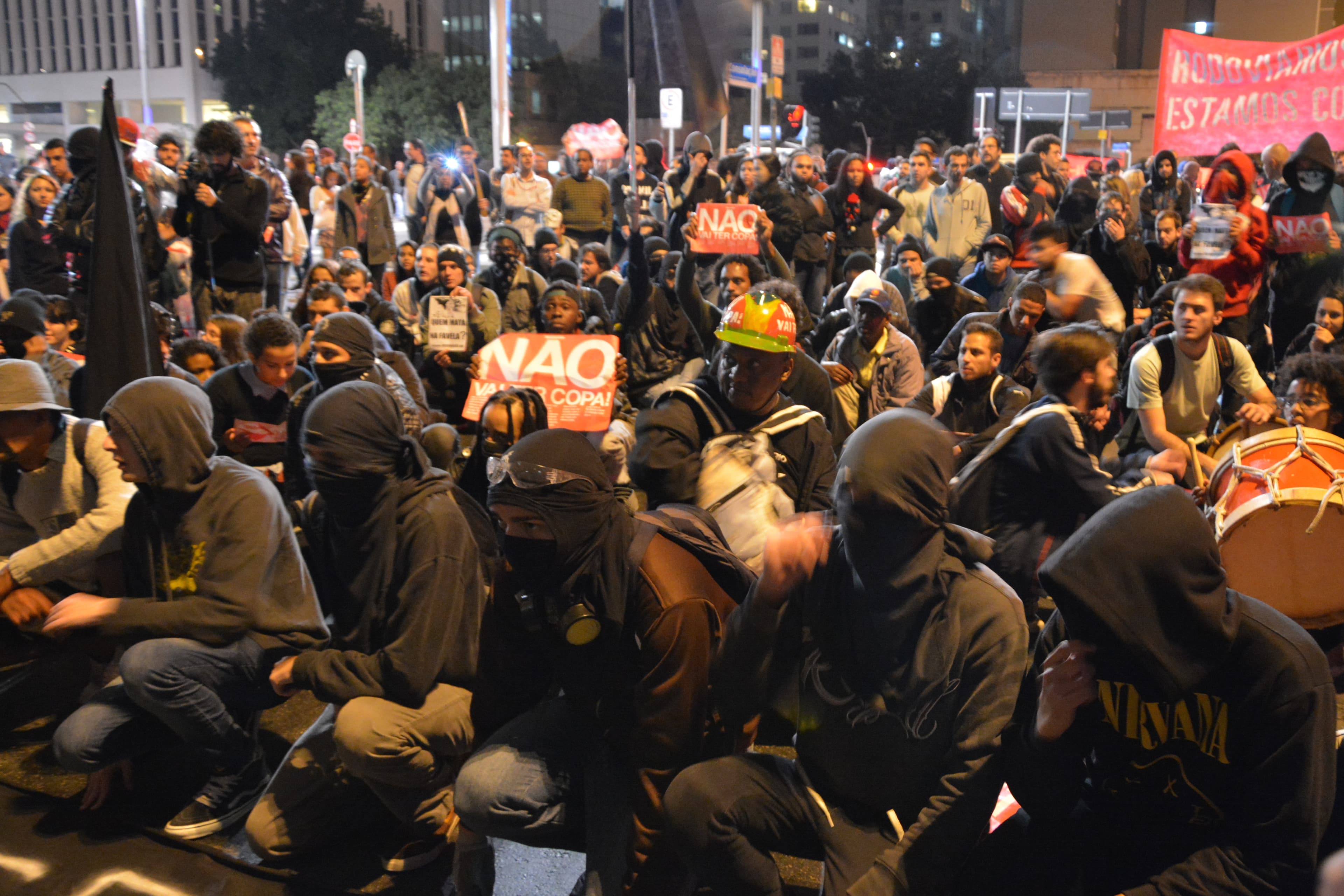 Nighttime street protest in Sao Paulo with signs against the World Cup.